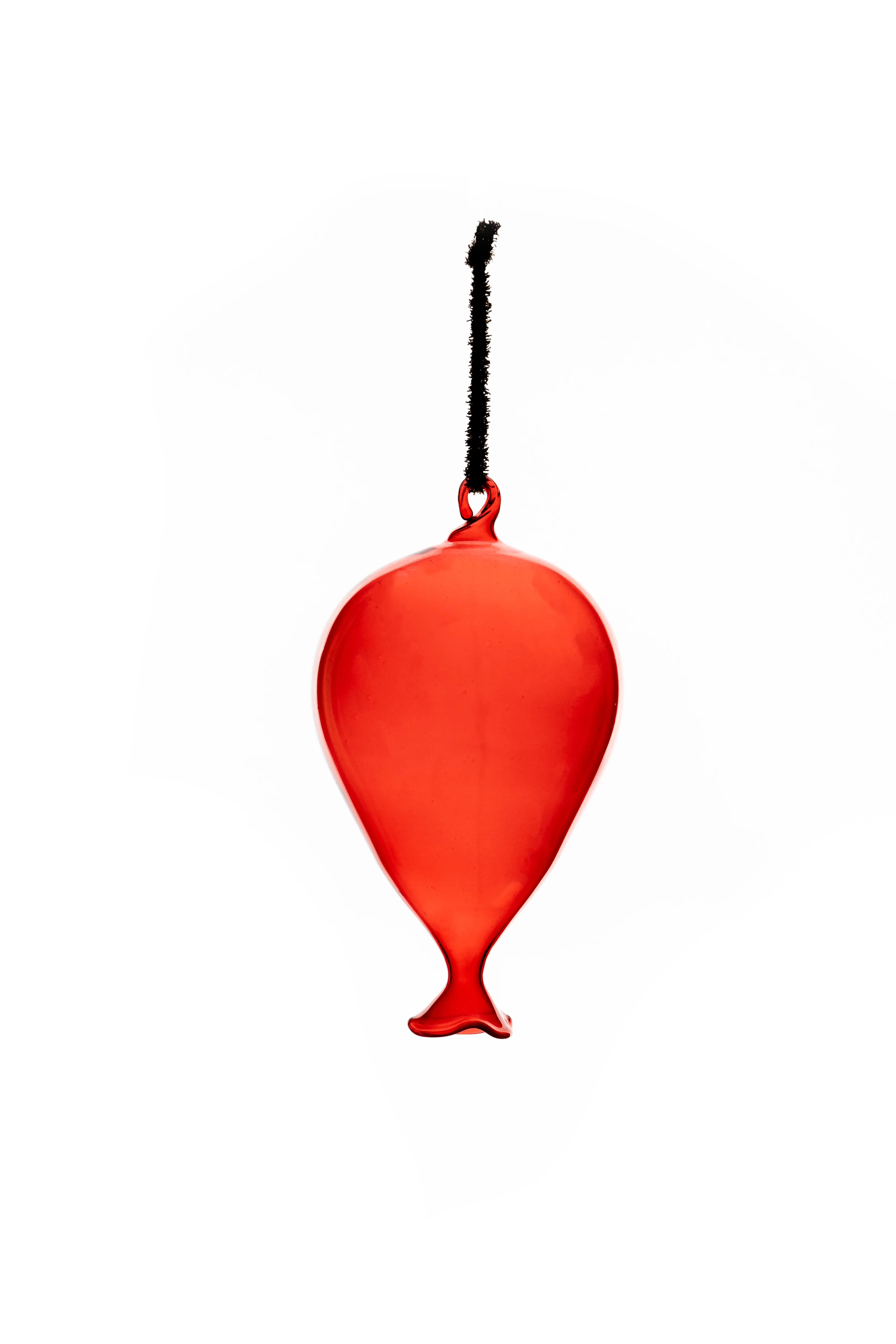 A red glass balloon-shaped ornament on a black cord, hanging against a white background.