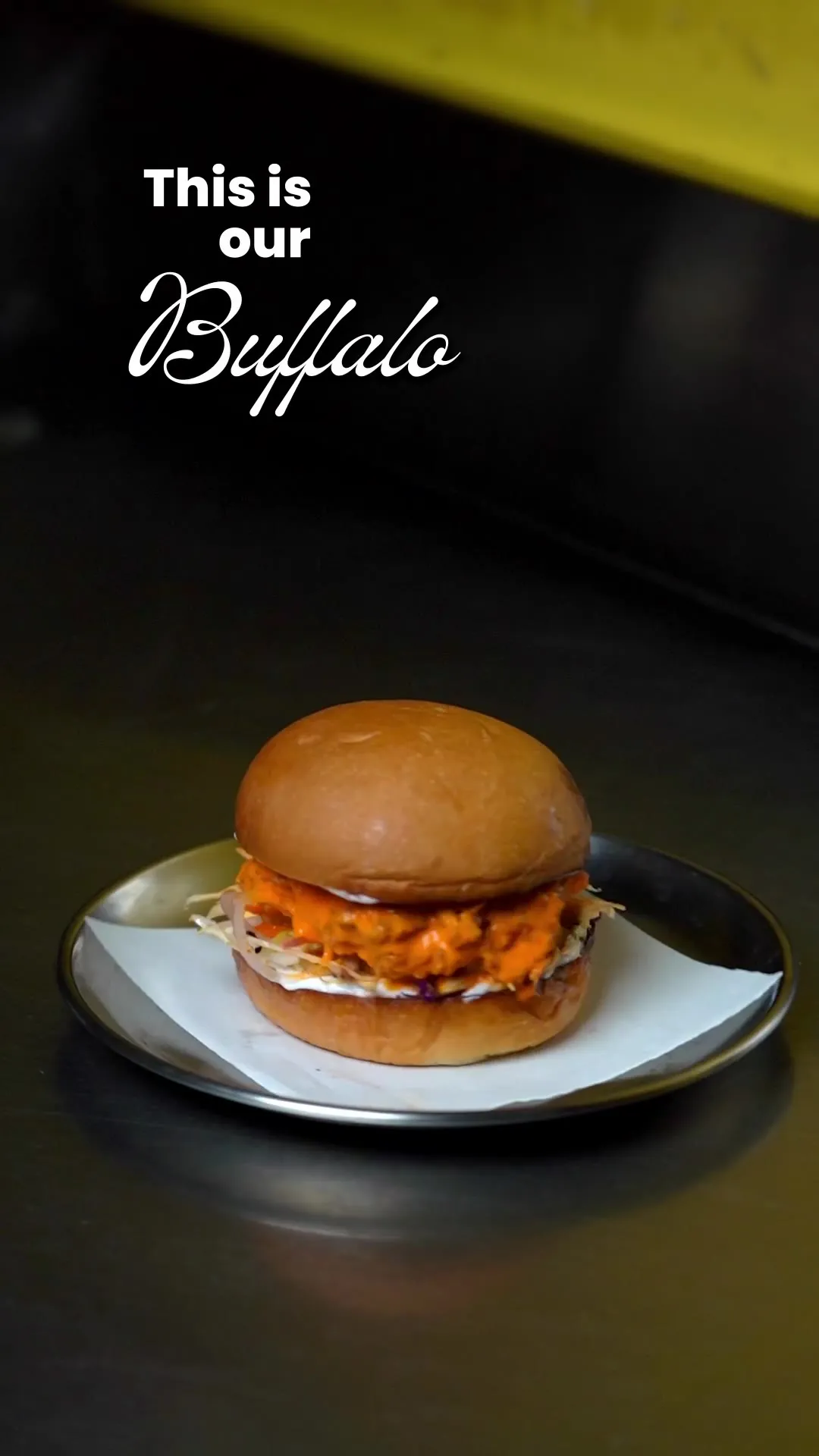 A buffalo chicken sandwich on a bun, captioned "Buffalo."