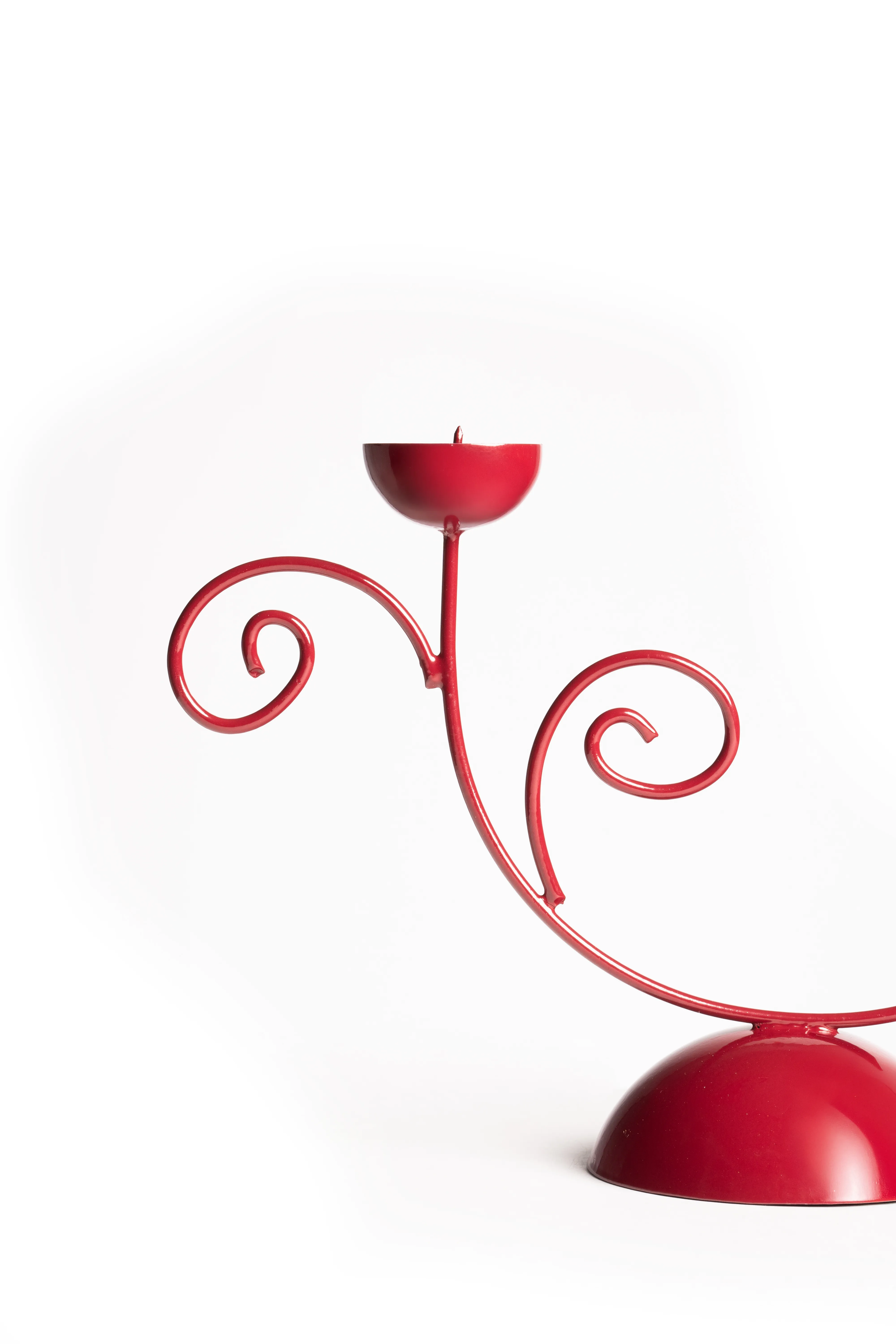 The full red scrollwork double candle holder standing on its dome base against a white background.