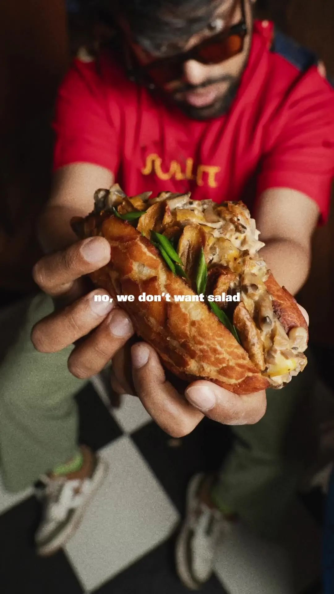 Hands holding a stuffed sandwich, captioned "no, we don't want salad."