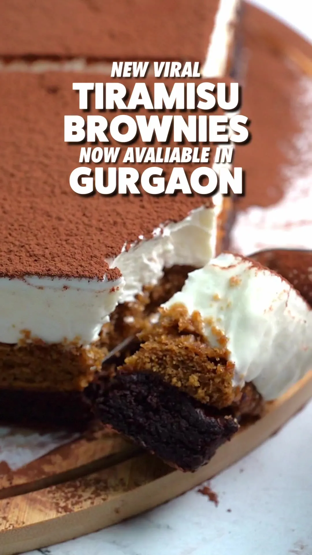 A cocoa-dusted tiramisu brownie sliced open to show its cream and brownie layers, captioned "New Viral Tiramisu Brownies now available in Gurgaon."